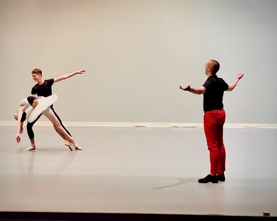 Ian Parsons, in red trousers, gives expansive notes to two dancers in a rehearsal studio.