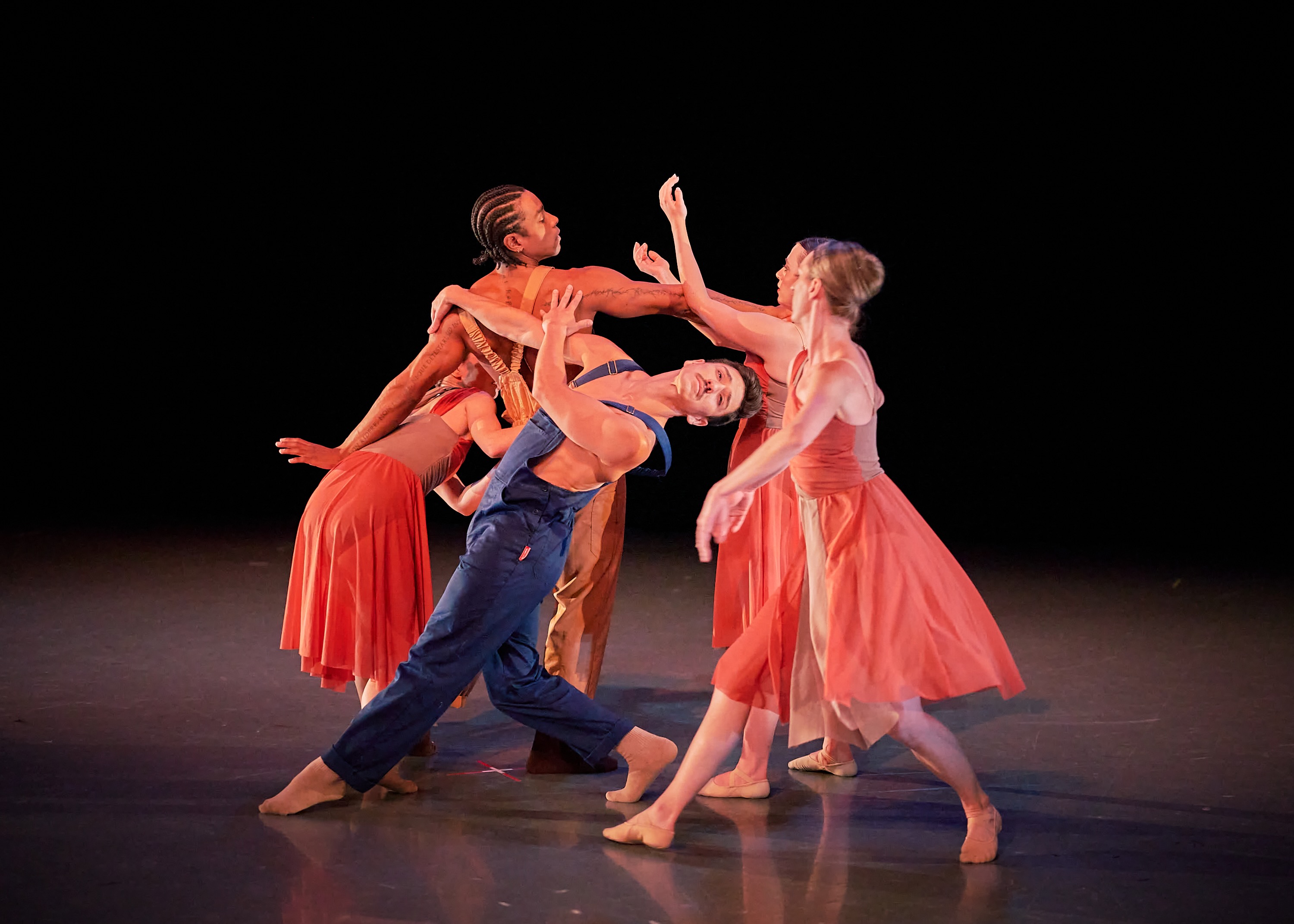 Five dancers converge in an expressive, sculptural ensemble arrangement.